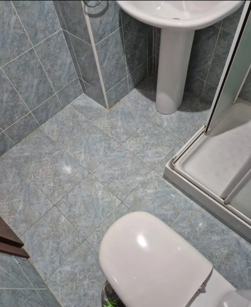 Reforma de baño completa con ducha, mampara negra y mueble suspendido (antes)