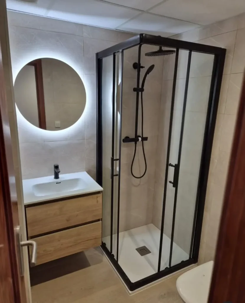 Reforma de baño completa con ducha, mampara negra y mueble suspendido (después)